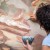 Restorer working on antique outdoor chapel fresco in Italy: Applying stucco plaster